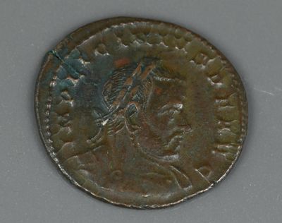 une vieille pièce de monnaie sur laquelle figure un oiseau, posée sur une table