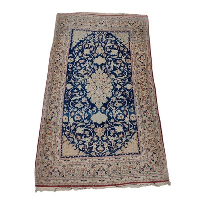 un tapis persan ancien, avec une bordure bleue et un motif floral