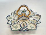 une assiette munie d'une anse et ornée d'un motif floral