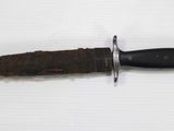 a knife that is laying on top of a piece of paper