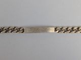 gros plan d'un bracelet en argent sur une surface blanche