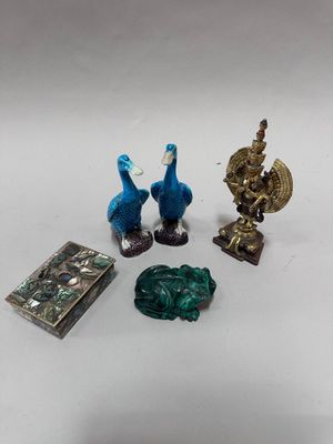 three figurines of birds and a book on a table