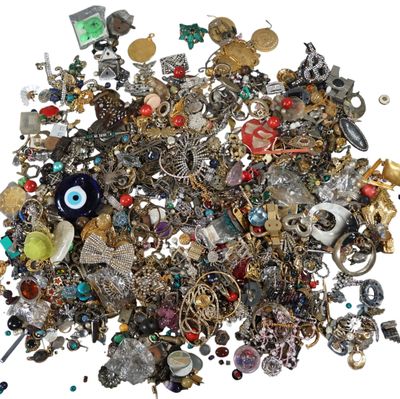 a pile of assorted jewelry on a white surface