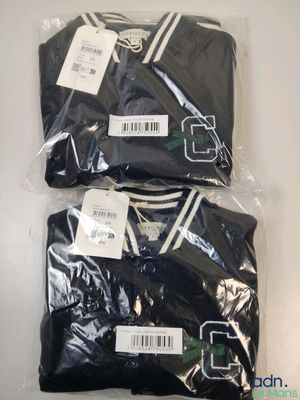trois t-shirts noirs à rayures blanches sont emballés dans du plastique