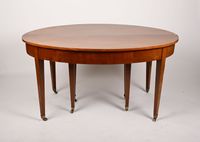 Table ovale en placage de noyer reposant sur huit pieds fuse…
