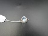 un gros plan d'une bague en or blanc sertie d'une topaze bleue