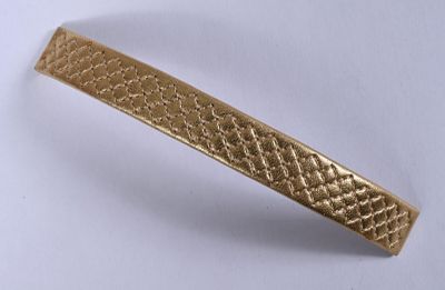 une image d'un gros plan d'un bracelet en or sur une surface blanche