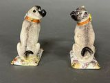 two figurines of cats sitting on top of each other