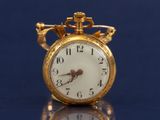 une montre de poche en or posée sur une table, sur un fond bleu
