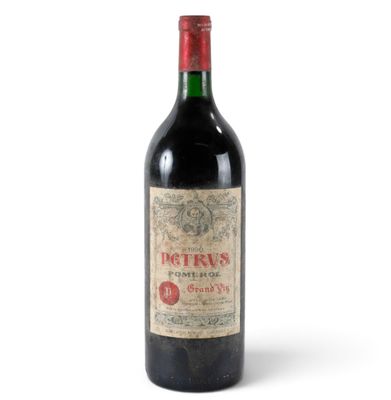 a bottle of red wine sitting on top of a white table