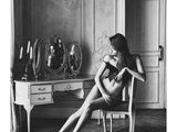 photographie en noir et blanc d'une femme assise sur une chaise devant un miroir