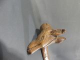 a close up of a wooden stick with a bird head on it
