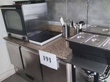 une petite cuisine équipée d'un micro-ondes, d'une cuisinière, d'un évier et d'un four à micro-ondes