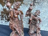 pair of bronze figurines of a woman and a man holding water jugs