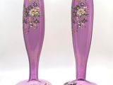 une paire de vases violets ornés de motifs floraux sur fond blanc