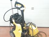 un nettoyeur haute pression jaune et noir posé par terre à côté d'une porte de garage
