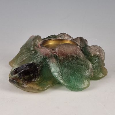 une bougie verte posée sur une table blanche