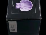 packaging of a purple flower in a black box on a black background