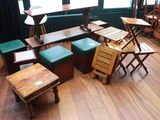 de nombreuses tables et tabourets en bois dans une pièce
