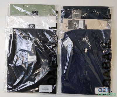 deux sacs de vêtements sont emballés dans du plastique et posés sur une surface blanche