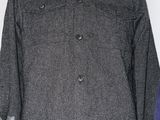 a gray jacket on a shelf next to a laptop