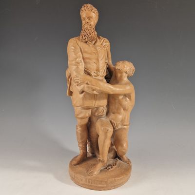 statue of a man holding a child and a dog on a pedestal