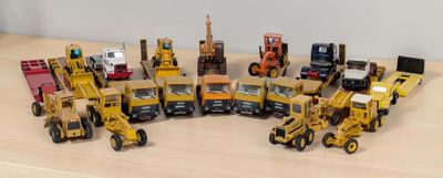 plein de petits engins de chantier en jouets posés sur une table