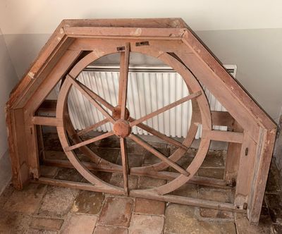 une roue en bois posée dans un coin d'une pièce