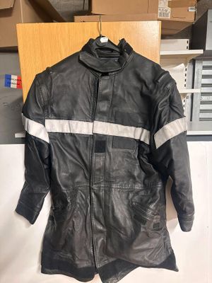 une veste en cuir noir à rayures blanches suspendue à un cintre