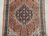 un tapis persan ancien, orné d'un motif géométrique et de franges