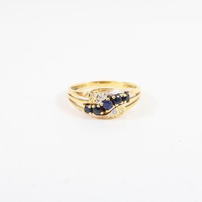 a close up of a gold ring with a sapphire and diamond