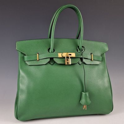 un sac à main en cuir vert avec des finitions dorées sur la poignée