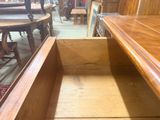 a wooden table with a drawer in the middle of it