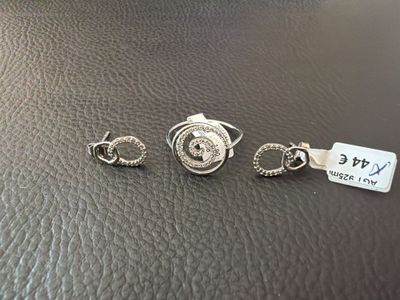 trois bijoux en argent posés sur une surface en cuir noir