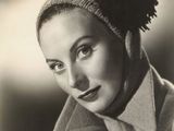 photographie en noir et blanc d'une femme portant un chapeau et un manteau