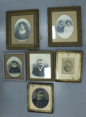 de nombreuses photos encadrées d'hommes et de femmes accrochées au mur