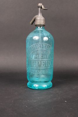 an old blue glass bottle with a metal spigot on top