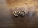 une paire de bagues en or serties de diamants posées sur une table en bois