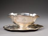a silver cup and saucer on a silver plate