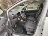 the interior of a car with the door open and the driver ' s seat down