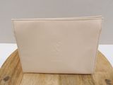 beige leather wallet on wooden table with white wall in background