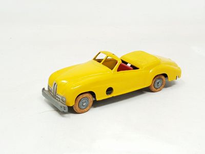 a yellow toy car that is on a white surface