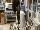 une statue représentant une femme tenant un lustre dans une pièce