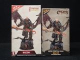 deux boîtes contenant chacune des figurines représentant un démon et un autre démon, sur fond noir