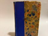 a small book with a blue cover sitting on a table