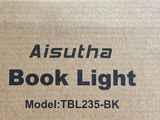 quelqu'un tient une boîte sur laquelle est posée une lampe de lecture