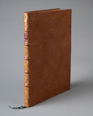 un vieux livre à la couverture brune posé sur une table