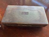 a silver box sitting on a wooden table next to a pair of scissors