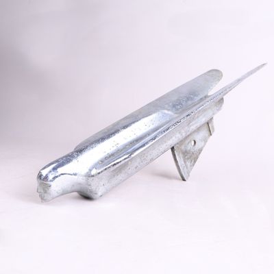 un objet métallique qui ressemble à un avion sur fond blanc