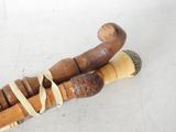 two wooden walking canes tied together on a white surface